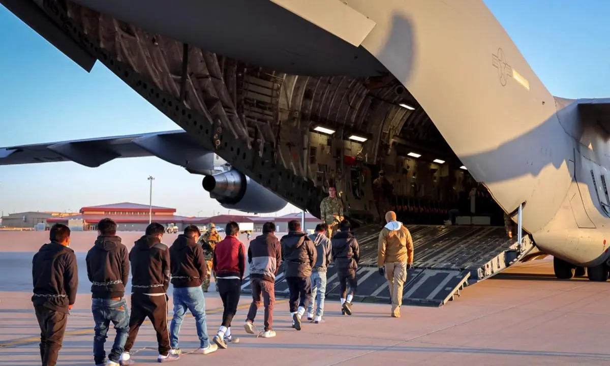 Migrantes ingresando a un avión para ser deportados