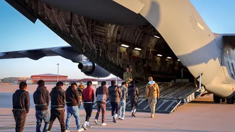 Migrantes ingresando a un avión para ser deportados